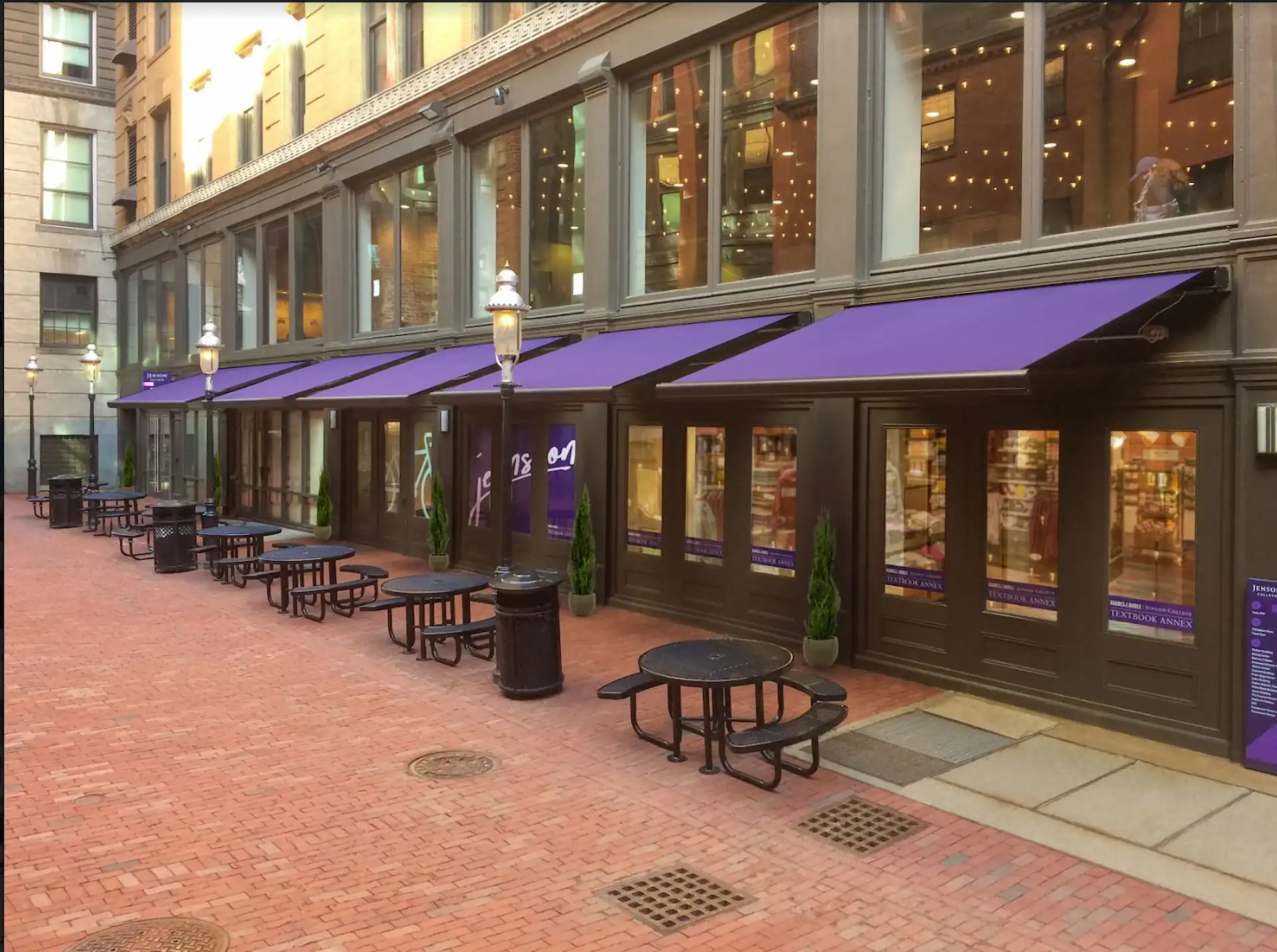 Exterior shot of an upscale store with a violet commercial awning extended from 5 windows on the facade.