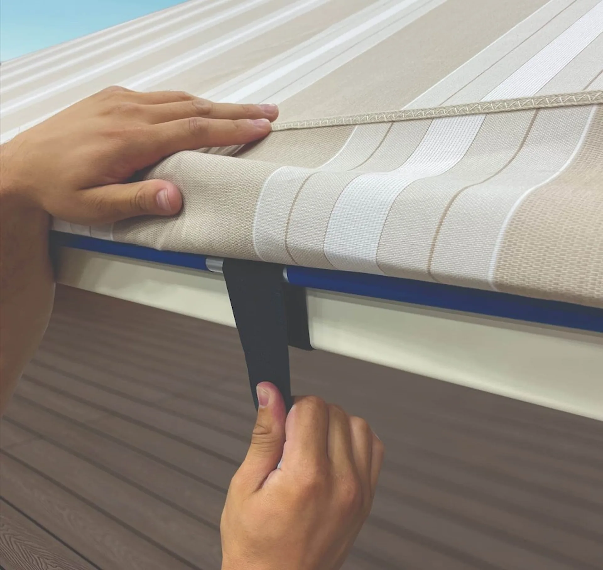 Close up on a pair of hands loosening the tension straps on an open air cabana cover.